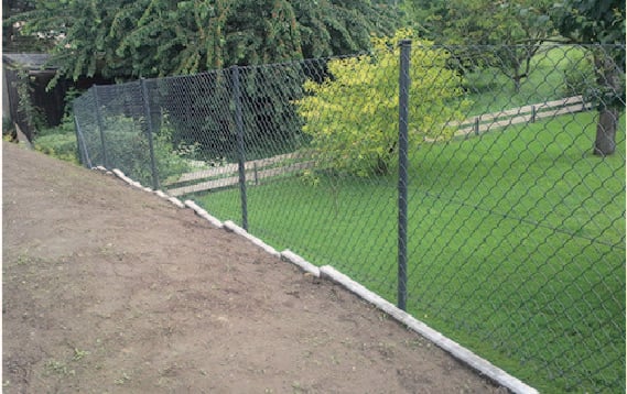 Munkások drótkerítést készítenek elő a raktárban