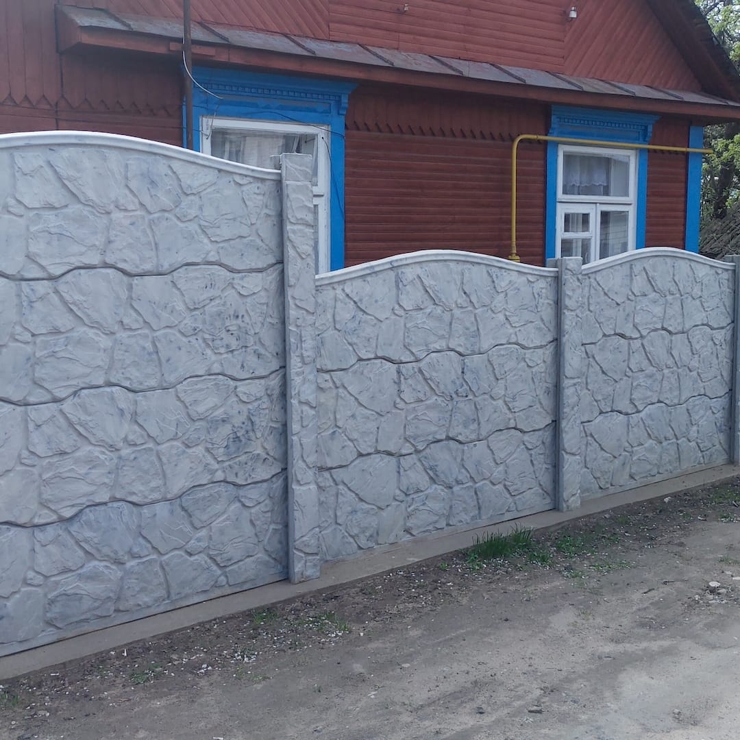 Egy betonelemes kerítésepítő betonelemes kerítés építés közben Fóton