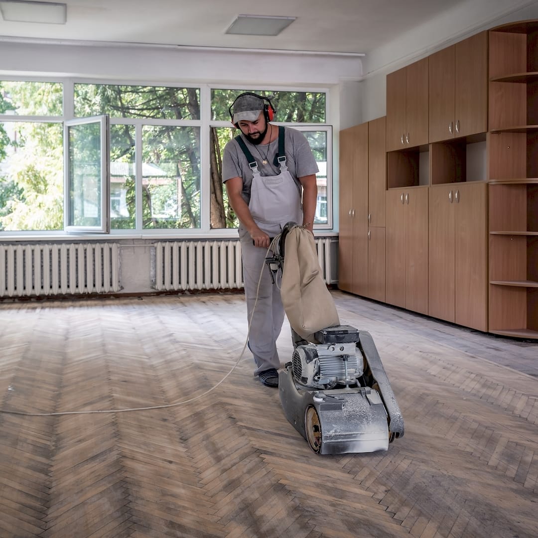 Egy parkettázó parketta csiszolás közben Mezőkövesden