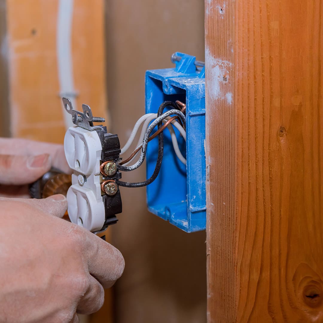 Egy villanyszerelő régi elektromos vezetékek cseréje közben Rakamazen