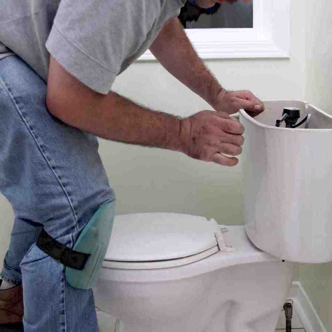 Egy wc csészecserét végző szakembernek, wc csésze cseréje közben Dunaújvárosban
