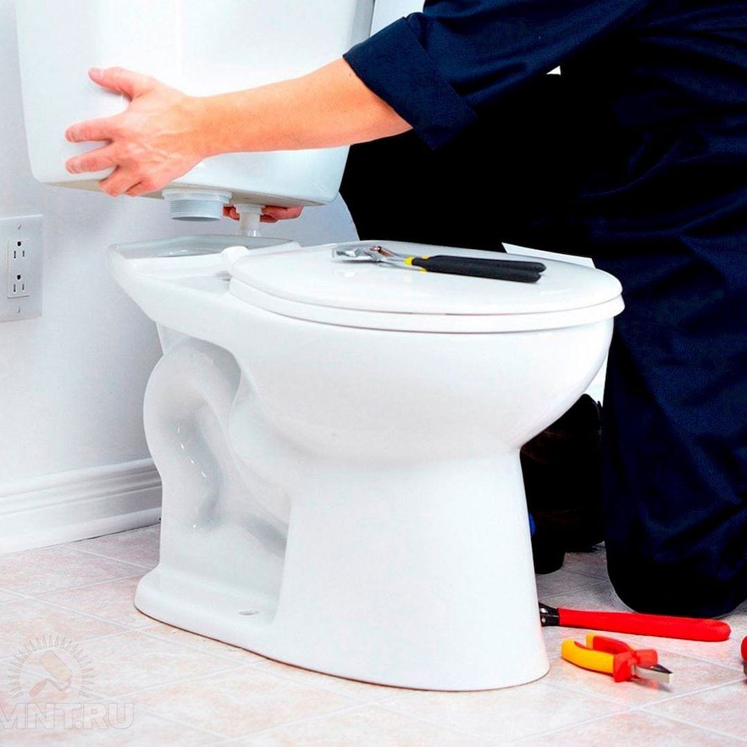 Egy szakember, aki végzi a wc tartály cseréjét, wc tartály csere közben Dunaújvárosban