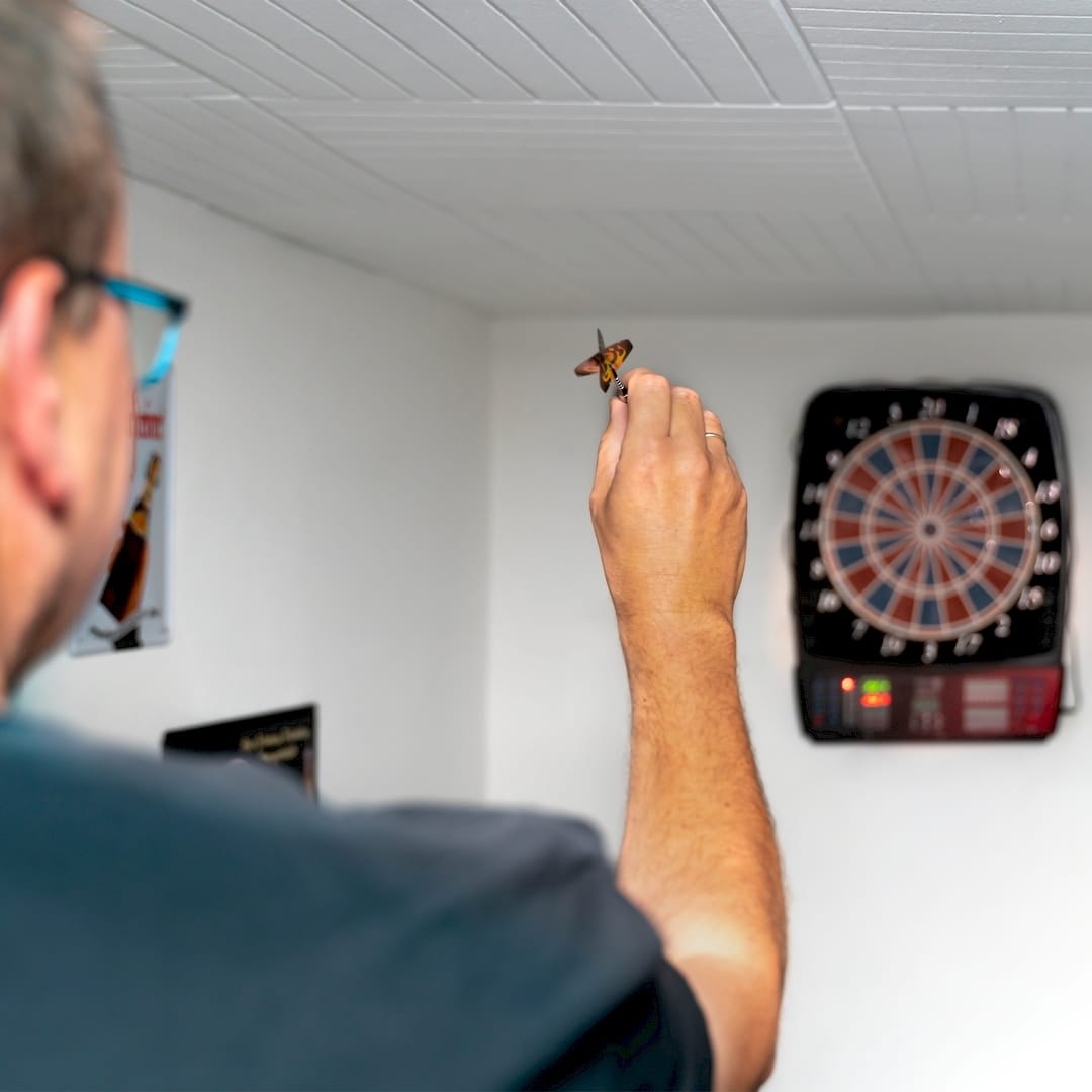 Egy sportedző darts edzés közben Táten