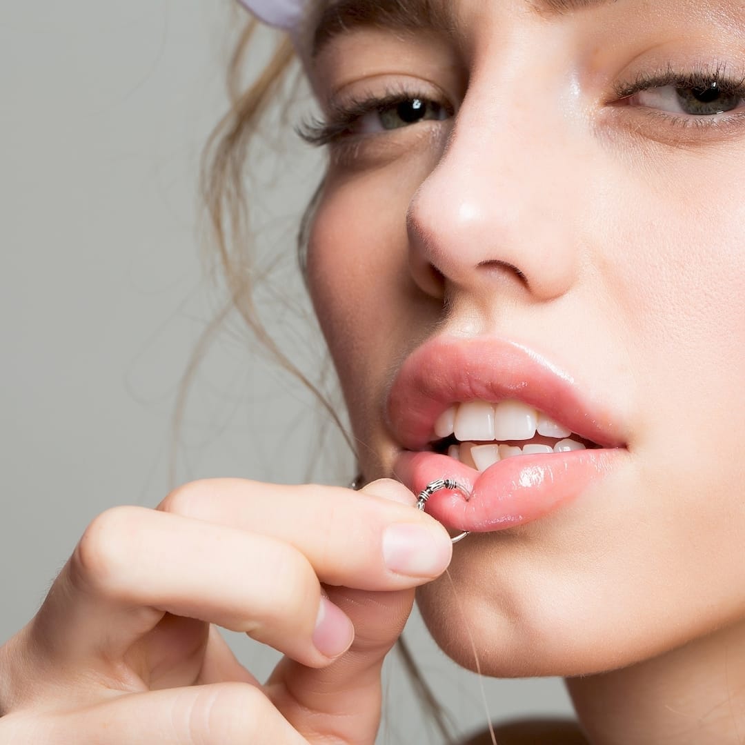 Egy piercer ajak piercing szúrás közben Veszprémben