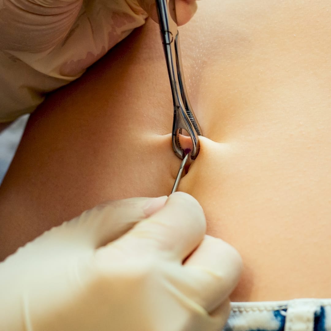 Egy piercer köldök piercing szúrás közben Veszprémben