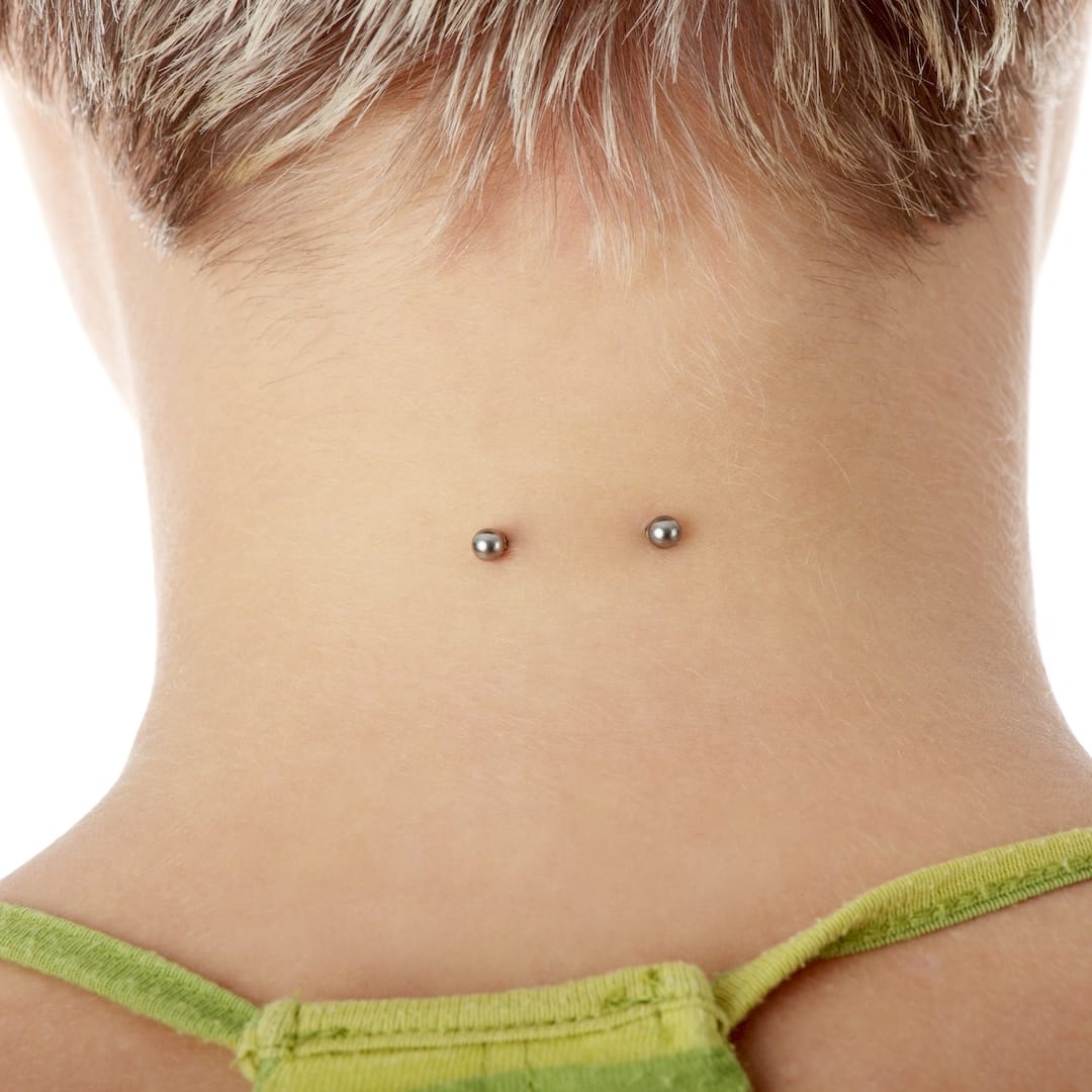 Egy piercer microdermal piercing szúrás közben Nyírmadan