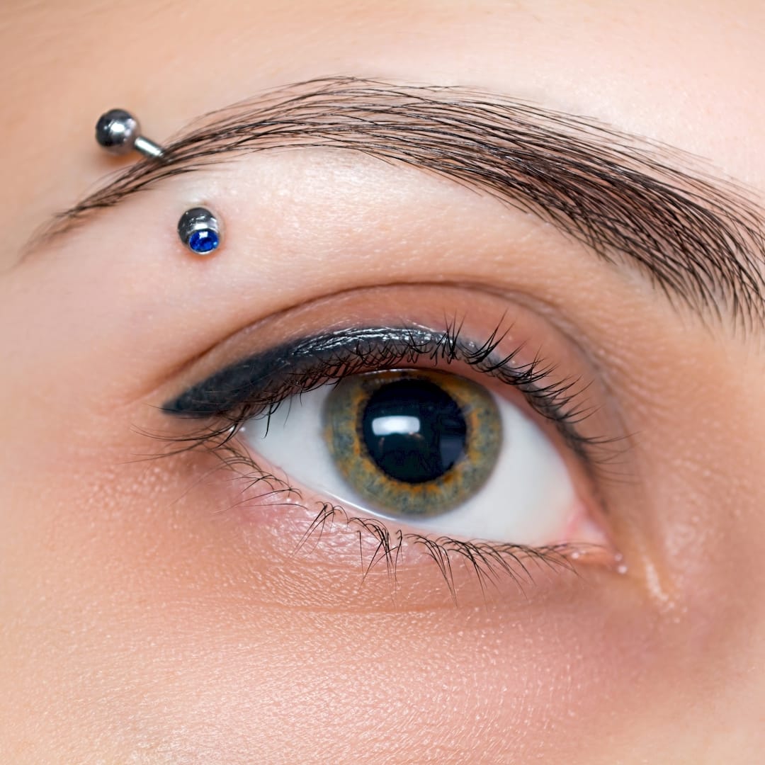Egy piercer szemöldök piercing szúrás közben Salgótarjánban