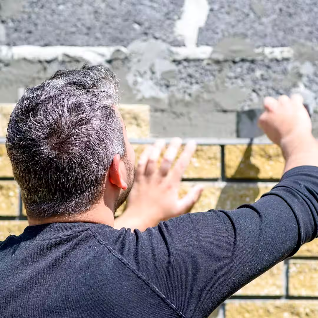 Egy kőműves kerítés építés kőből közben Bonyhádon