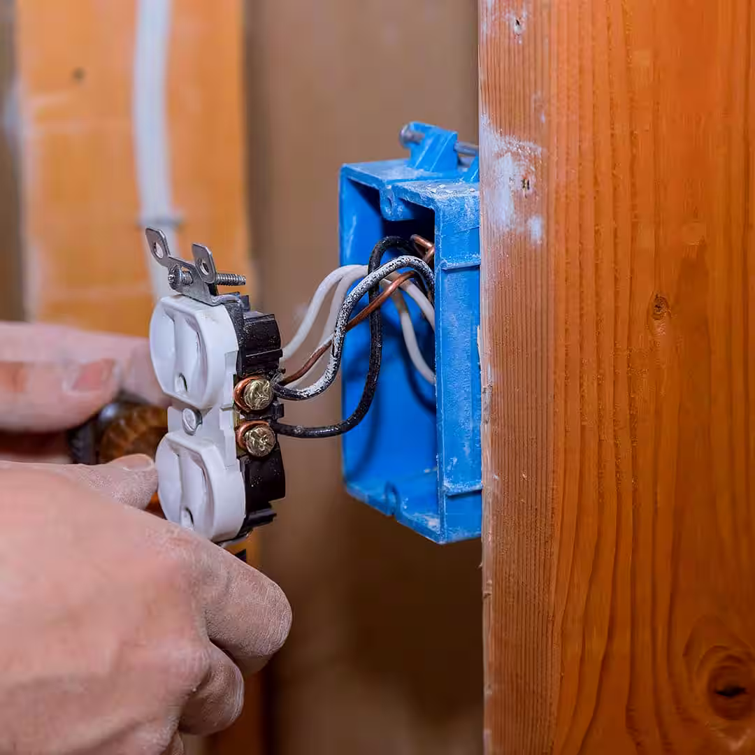 Egy villanyszerelő régi elektromos vezetékek cseréje közben Nagykállóen