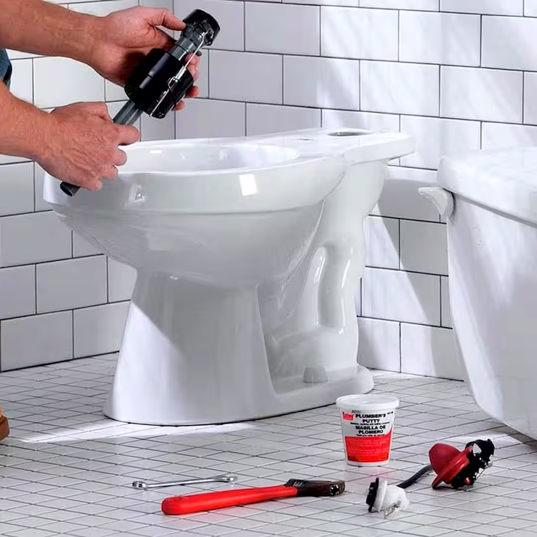 Egy szakember, aki elvégzi a wc-csésze beszerelését, wc csésze beszerelése közben Szigetszentmiklósen