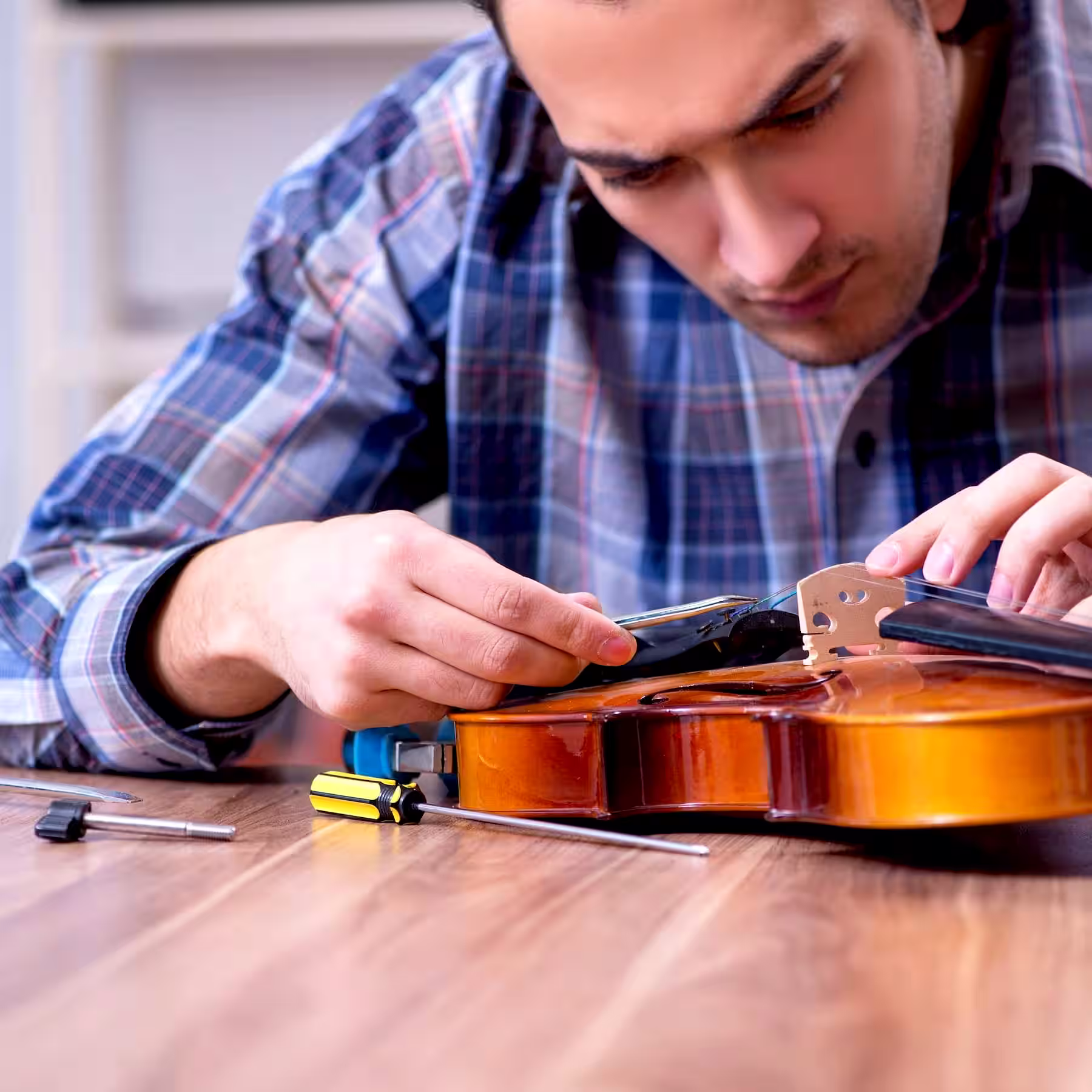 Egy hangszerjavító akusztikus gitár javítás közben Mezőhegyesen